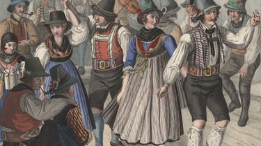 HANDOUT - 09.04.2024, Bayern, Tegernsee: Eine kolorierte Lithographie aus der Zeit um 1825 mit dem Titel »Kirchweih-Tanz in der Umgegend von Tegernsee« zeigt Menschen in zeitgenössischer Tracht beim Tanz. Die Tänzer tragen dabei Frisuren bei denen die Haare deutlich unter den Hüten hervorschauen. Im oberbayerischen  Trostberg ist nun eine Debatte um die Frisuren von Trachtlern entbrannt. Zwei Söhne einer Familie waren bisher leidenschaftliche Schuhplattler. Weil im örtlichen Trachtenverein die längeren Haare der Jungen kritisiert wurden, ist die sechsköpfige Familie mit beiden Söhnen und zwei Töchtern geschlossen ausgetreten. Foto: Bezirk Oberbayern/Sammlung Bayerischer National-Costüme/dpa - ACHTUNG: Nur zur redaktionellen Verwendung im Zusammenhang mit der aktuellen Berichterstattung und nur mit vollständiger Nennung des vorstehenden Credits +++ dpa-Bildfunk +++ | Bild: dpa-Bildfunk/---